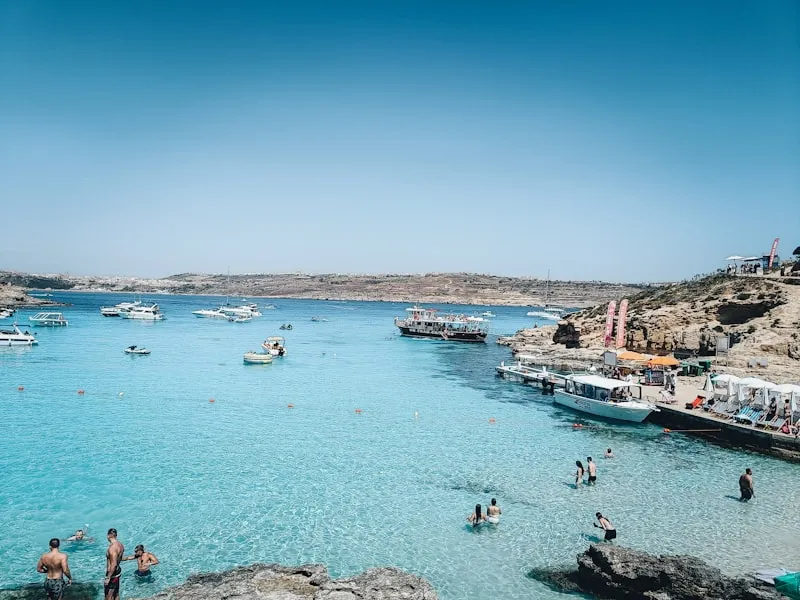 Gente nadando en aguas turquesa de Comino en Malta