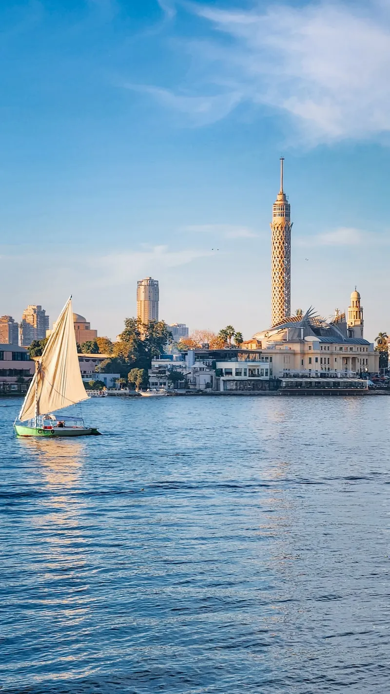 Velero en el Nilo con ciudad al fondo
