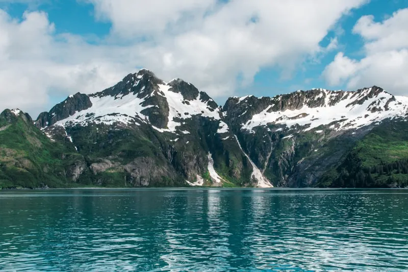 Montañas nevadas reflejadas en lago en Alaska